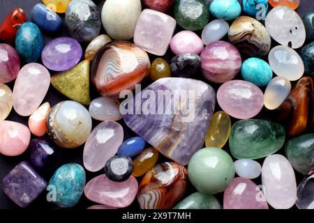 Fond fait de belles pierres semi-précieuses de couleur naturelle. Gros plan sur la fluorite violette, le quartz rose et l'agate. Banque D'Images