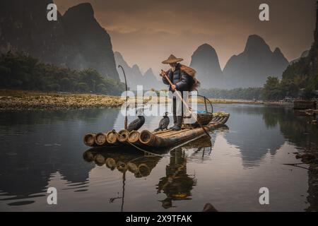 20 JANVIER 2022, GUILIN, CHINE : un pêcheur traditionnel de cormorans travaille sur la rivière Li Yangshuo, Chine. Copier l'espace pour le texte Banque D'Images