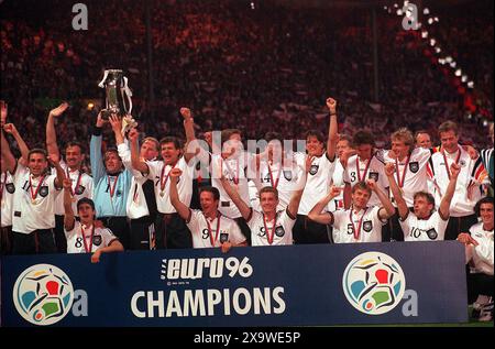 Photo du dossier datée du 30/06/96 de l'Allemagne célébrant avec le trophée Euro 96. Les hôtes partagent le record avec l'Espagne pour le plus grand nombre de titres et cherchent un quatrième record cet été. Date d'émission : lundi 3 juin 2024. Banque D'Images