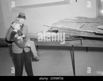 Effectif 1946 : réunion de 5 ans. La rencontre de l'enfant de 5 ans avec le passé. Stein Erik lors d'une visite du musée. Ci-dessous : conservateur. Johannessen au musée des navires vikings soulève Stein-Eirik pour qu'il puisse mieux voir. Maintenant, c'est le Tuneskipet qui est l'objet de son intérêt. Le thonier a été tellement endommagé lorsqu'il a été excavé qu'aucune reconstruction sûre n'a été possible. Le plus grand des navires vikings qui ont été trouvés etrestaurés, est le navire Oseberg. Photo : aktuell / NTB Banque D'Images