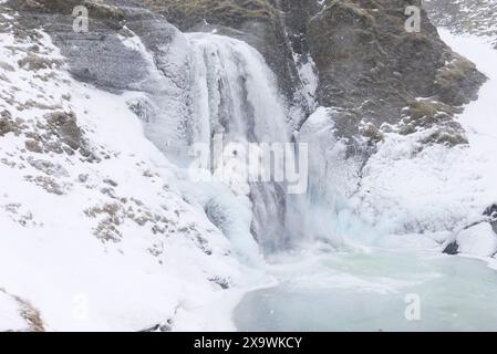 . Cascade Helgufoss couverte de glace au début du printemps. Islande Banque D'Images