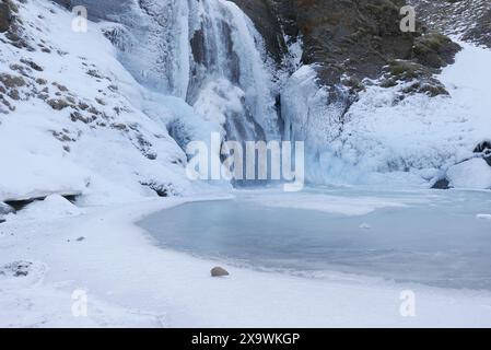 . Cascade Helgufoss couverte de glace au début du printemps. Islande Banque D'Images