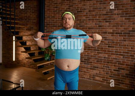 Drôle homme chubby dans les vêtements de sport tromper autour de l'équipement de fitness Banque D'Images