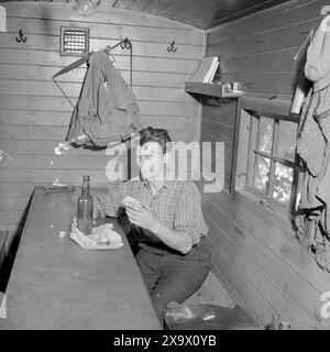 Réel 03- 1945 : une famille de ville assez ordinaire. Torger Kjus, ouvrier de la construction, prend son petit déjeuner dans la caserne à manger. La nourriture n'est pas si somptueuse. Il y a des sandwichs avec des gâteaux de hareng sur eux et il boit un substitut de café avec la nourriture. Photo : th. Skotaam / Aktuell / NTB ***photo non traitée*** Banque D'Images