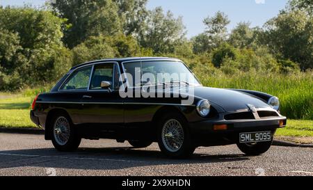 Stony Stratford, Royaume-Uni - 2 juin 2024 : 1977 noir MGB GT voiture classique conduite sur une route de campagne britannique Banque D'Images