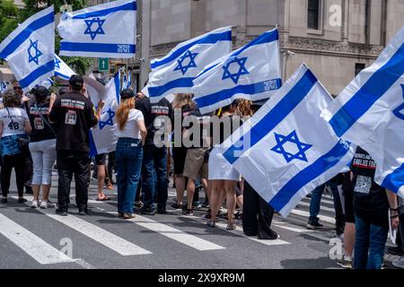 New York, États-Unis. 02 juin 2024. Les partisans d'Israël encouragent le défilé avec des drapeaux israéliens. La 59e parade annuelle de la Journée d'Israël marche sur la 5e Avenue le long de Central Park. Le défilé célèbre la culture et la fierté israéliennes. Le défilé a pris un ton sombre cette année au milieu de la guerre Israël-Hamas, avec pour objectif principal de ramener chez eux les 120 otages restants encore à Gaza qui ont été enlevés le 7 octobre 2023. Crédit : SOPA images Limited/Alamy Live News Banque D'Images