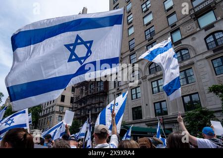 New York, États-Unis. 02 juin 2024. Les partisans d'Israël encouragent le défilé avec des drapeaux israéliens. La 59e parade annuelle de la Journée d'Israël marche sur la 5e Avenue le long de Central Park. Le défilé célèbre la culture et la fierté israéliennes. Le défilé a pris un ton sombre cette année au milieu de la guerre Israël-Hamas, avec pour objectif principal de ramener chez eux les 120 otages restants encore à Gaza qui ont été enlevés le 7 octobre 2023. Crédit : SOPA images Limited/Alamy Live News Banque D'Images