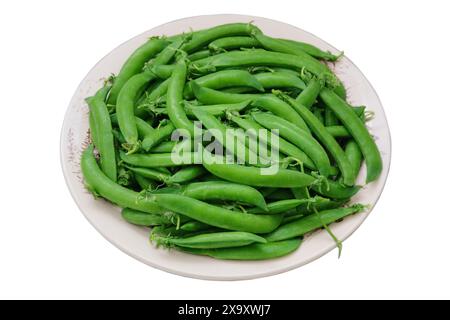 Pois verts dans une assiette isolée sur fond blanc. Petits pois frais dans un bol. Bols de légumes. Banque D'Images