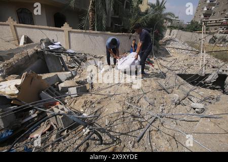 Les Palestiniens collectent les effets personnels restants dans les décombres des maisons détruites après les attaques israéliennes les Palestiniens collectent les effets personnels restants dans les décombres des maisons détruites après les attaques israéliennes contre la maison appartenant à la famille Abu El-Nar lors de l'attaque israélienne contre le camp de réfugiés de Nusairat à Deir Al Balah, Gaza, le 3 juin 2024. Photo Omar Ashtawy apaimages Nusairat bande de Gaza territoire palestinien 030624 Nusairat OSH 0033 Copyright : xapaimagesxOmarxAshtawyxxapaimagesx Banque D'Images