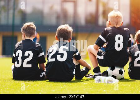 Garçons dans l'équipe de football. Les enfants jouent un match dans la Ligue de football des jeunes. Vos amis s'amusent à jouer au tournoi de football en plein air. Membres de l'équipe sportive scolaire dans Banque D'Images