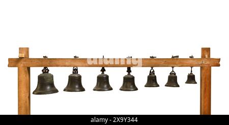 Ensemble de cloches d'église suspendues de différentes tailles sur un cadre en bois isolé sur un fond blanc Banque D'Images