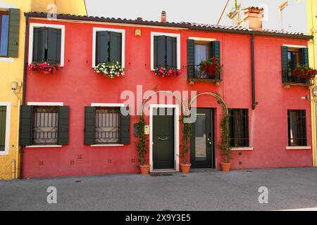 Vue d'une maison rouge avec des fleurs sur les balcons, à Piazza Portello. 27 mai 2024 Padoue, Vénétie, Italie Banque D'Images