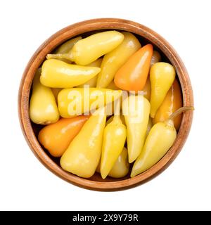 Poivrons chauds jaunes marinés, dans un bol en bois. Petit piment chaud, pepperonis, ou piment de Capsicum, pasteurisé et conservé dans une saumure de vinaigre. Banque D'Images