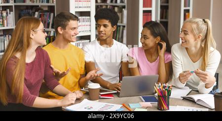 Groupe d'adolescents multinationaux travaillant sur un projet à la bibliothèque Banque D'Images