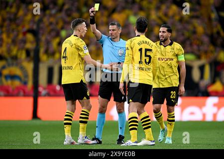 01 juin 2024, Royaume-Uni, Londres ; : la finale de la Ligue des Champions entre le Borussia Dortmund et le Real Madrid au stade de Wembley samedi a vu un test de la nouvelle règle selon laquelle seul le capitaine de chaque équipe peut s'adresser à l'arbitre, qui sera appliquée lors du Championnat d'Europe en Allemagne. Sur la photo, l'arbitre de la finale de Wembley, le slovène Slavko Vincic, montre le carton jaune à l'international Nico Schlotterbeck, pour avoir protesté, en présence de son coéquipier Mats Hummels et du capitaine de l'équipe allemande Emre Can. Photo : Robert Michael/dpa Banque D'Images