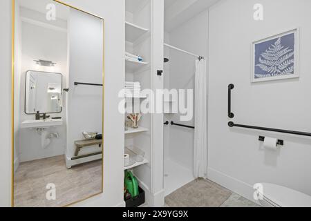 Salle de bains avec armoire blanche, miroir, toilettes et lavabo Banque D'Images