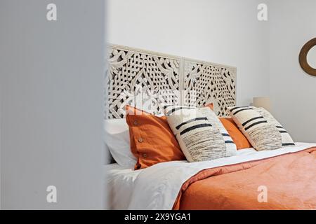 Lit blanc près de la commode en bois par la fenêtre Banque D'Images