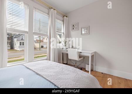 Une chambre dotée d''une fenêtre spacieuse et d''un bureau blanc Banque D'Images