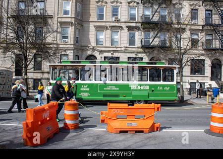 Un chariot vert passe devant des barricades orange dans une rue de New York Banque D'Images