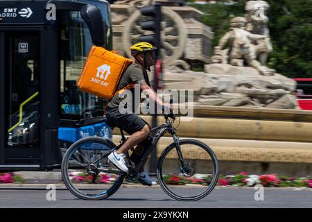 Madrid, Espagne. 03 juin 2024. Un livreur fait du vélo devant la fontaine de Cibeles lors de la Journée internationale du vélo. La Journée internationale du vélo est célébrée chaque 3 juin, après avoir été déclarée en 2018 par l'Assemblée générale des Nations Unies. Crédit : SOPA images Limited/Alamy Live News Banque D'Images