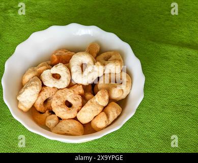Un bol blanc avec taralli sur un chiffon vert Banque D'Images