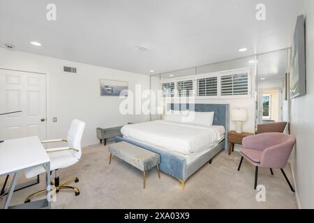 Une chambre principale spacieuse avec un lit, un bureau et un dressing à Hidden Hills, CA Banque D'Images