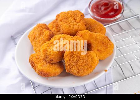 Nuggets de poulet frits dorés traditionnels sur une assiette, avec sauce ketchup. Banque D'Images