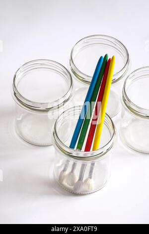 Les pinceaux assortis dans un pot en verre sur fond blanc Banque D'Images