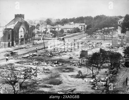 Une partie du district incendiée par des émeutes raciales, Tulsa, Oklahoma - la photographie montre des ruines de bâtiments, dont une église, détruits pendant le massacre de Tulsa Race, également appelé Tulsa Race Riot, quand une foule blanche a attaqué le quartier à prédominance afro-américaine Greenwood de Tulsa, Oklahoma, juin 1921 Banque D'Images