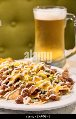 Une assiette de nachos et un verre de bière sur une table Banque D'Images