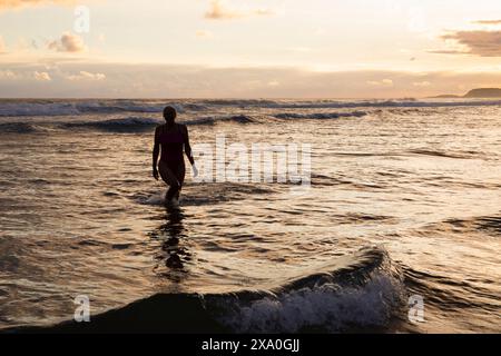 Europe, Espagne, Gipuzkoa, plage de Zarautz avec femme retraitée se baignant à Dawn Banque D'Images