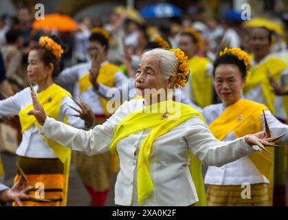 Des artistes thaïlandais vêtus de costumes traditionnels exécutent la danse thaïlandaise Lanna lors de la procession de la statue de Bouddha de Phra Bouddha Fon Saan Haa pour marquer la cérémonie du Festival Inthakin au Wat Chedi Luang à Chiang mai, Thaïlande. La cérémonie du Festival Inthakin est une tradition importante et unique à Chiang mai, en Thaïlande. Ce rituel implique le culte du pilier de la ville, connu sous le nom de 'Inthakin' (pilier Inthakin), qui est situé à Wat Chedi Luang. Au cours de cet événement, les habitants apportent des offrandes de fleurs, des bâtonnets d'encens et des bougies, les plaçant dans des récipients pour être présentés au pilier Intakhin. Cet acte est p Banque D'Images