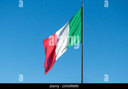 Drapeau national d'Italie dans un ciel bleu clair. Banque D'Images