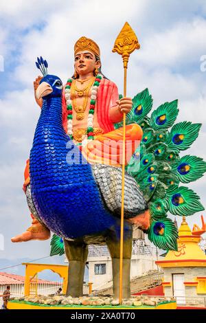 Statue bleue du Seigneur Shiva assise avec une peau de tigre, tenant un trident et affichant un geste de bénédiction. Orné de serpents et de perles, ce vibrant Banque D'Images