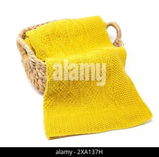 photographie d'une couverture tricotée jaune en motif de tricot diamant dans un panier isolé sur un fond blanc Banque D'Images