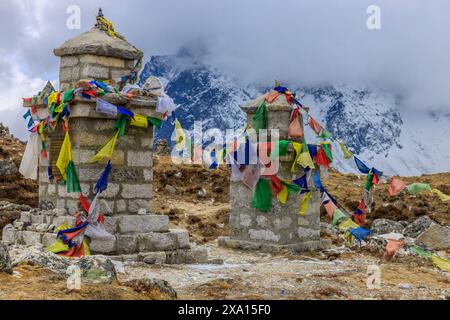 Drapeaux de prière népalais et tibétains colorés flottant dans les montagnes majestueuses du Népal. Symbolisant la paix, la compassion et les bénédictions, les drapeaux ornent le Banque D'Images
