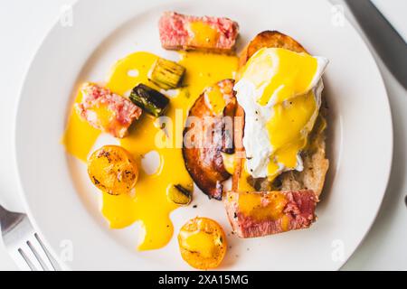 Toast avec thon, oeuf poché, asperges, tomate et sauce hollandaise gros plan sur fond blanc. Foyer sélectionné. Photo de haute qualité Banque D'Images