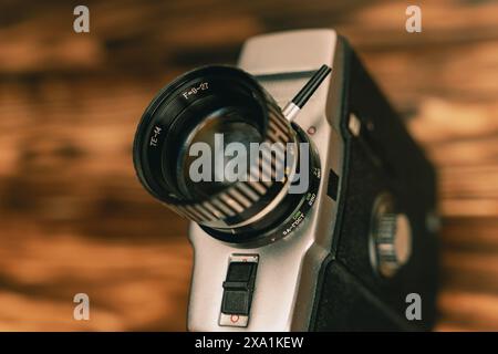 Gros plan d'un objectif de caméra de film vintage sur un fond en bois. 8 mm Banque D'Images