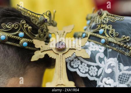 Une mariée et un marié échangent leurs vœux dans une église avec une croix au-dessus d'eux. Banque D'Images