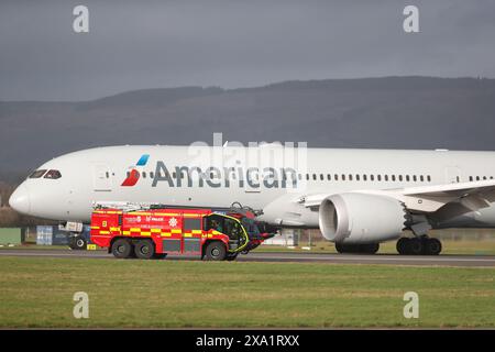 L'avion d'American Airlines sur la piste à côté d'un véhicule d'urgence à Glasgow, au Royaume-Uni. Banque D'Images