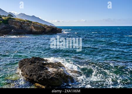 La rive rocheuse en Sicile est entourée de montagnes Banque D'Images