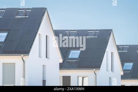 Rangée de maisons neuves sous le ciel bleu avec les toits solaires Banque D'Images
