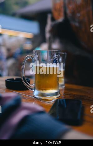 Un verre rempli de bière sur une table de bar Banque D'Images