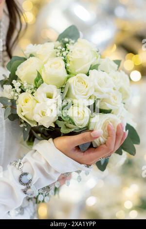 La femme tenant un bouquet de mariage avec un fond doré Banque D'Images