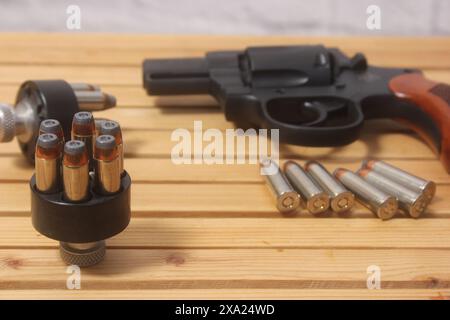 Un pistolet et des balles sur une table en bois Banque D'Images