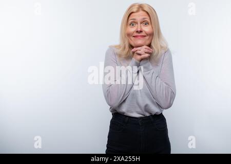 Charmante femme de 45 ans aux cheveux blonds est inspirée et surprise Banque D'Images