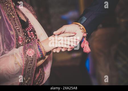 Un gros plan de mariée et mariée tenant la main, symbolisant l'amour et l'amitié Banque D'Images
