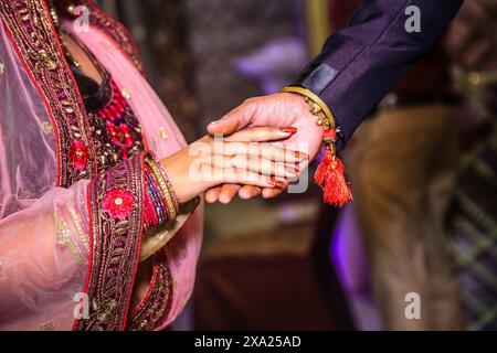 Un couple en tenue traditionnelle agrafe les mains Banque D'Images