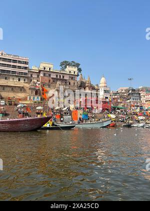 Un groupe de bateaux flottant sur l'eau près des structures Banque D'Images