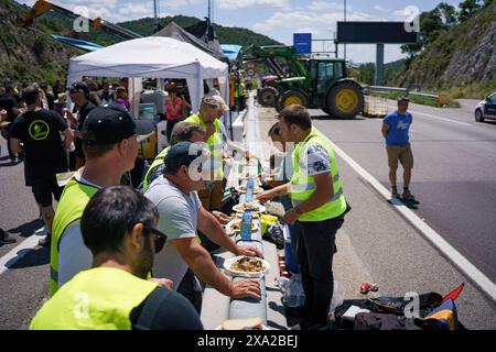 La Jonquera, Espagne. 03 juin 2024. Les manifestants déjeunent au milieu de la route pendant la manifestation. Des centaines d’agriculteurs espagnols et français ont bloqué les autoroutes aux principaux postes frontaliers entre les deux pays pour protester contre les réglementations de l’UE sur l’industrie, augmentant la fiscalité et l’importation de produits en provenance de pays étrangers. Crédit : SOPA images Limited/Alamy Live News Banque D'Images